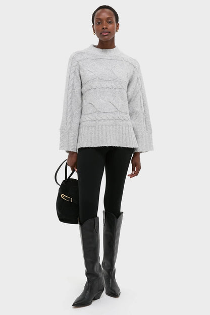 Gray Cableknit Gladwyn Sweater styled effortlessly with leggings and boots for a classic, high-end look, exuding fun and warmth with its chic cable-knit design.